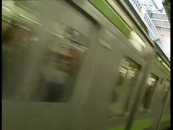 Angled shot of train wiping frame with waiting passengers reflected in carriage windows, Tokyo Stock Footage