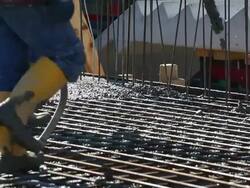 Workers Directing Concrete Onto The Construction Site CU Stock Footage