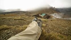 Pov of hiker's legs relaxing by the mountain lake Stock Footage