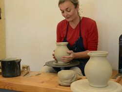 MS Shot of female potter finishing and put away pitcher on potterwheel at pottery / Landshut, Bavaria, Germany Stock Footage