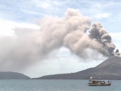 Boat floats on ocean as volcano erupts ash nearby, Krakatoa, Indonesia, November 2010 Stock Footage