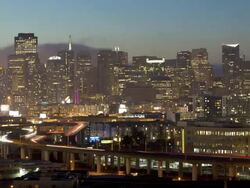 Time-lapse view of Fog rolling in from the Bay over the San Francisco skyline from Potrero Hill at night with highway tail lights leading to the commercial district, California, USA Stock Footage