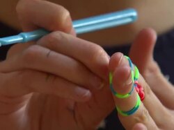 Girl playing with colourful Loom Bands News Clip