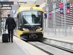 MS PAN Well dressed young man with suitcase in urban area walking next to commuter train / Minneapolis, Minnesota, United States Stock Footage