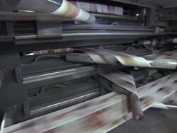 Medium tilt-up - Long sheets of printed paper roll through a printing press /  Wisconsin, United States Stock Footage