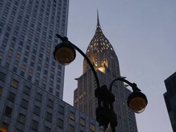 Chrysler Building stacked between apartment buildings at dusk. An old street lamp is featured. Stock Footage