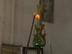 Glass blowing, molten glass is attached to side of vessel and is fashioned into a handle, Egypt, (sound available) Stock Footage