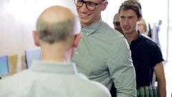 Smiling students shaking hands with mature teacher in computer class Stock Footage