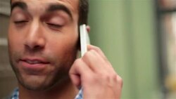 Man talks and laughs on smartphone outside green store-front in Soho Stock Footage