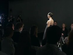 MS Female model wearing gown walking alone on catwalk in front of crowd at fashion show  Stock Footage