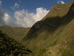 "Pan from forested hillside down to river at the base of valley, bright blue sky and white clouds, Amazonas region of Peru [PerÃƒÂº]" Stock Footage