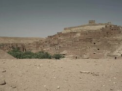 Buildings and dwellings ascending up the rugged hillside, surrounded by land and mountains. Stock Footage