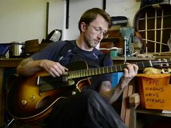 Craftsman 'Luthier' Nigel Forster making hand made Guitars Stock Footage