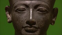 The statue of a pharaoh stands against a green wall. Stock Footage