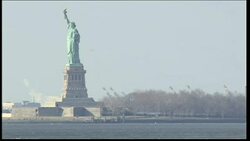 Statue of Liberty with tugboat passing News Clip
