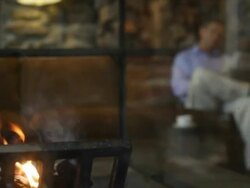 hotel lobby fireplace fire man newspaper reading coffee holiday vacation resort getaway lodge Stock Footage