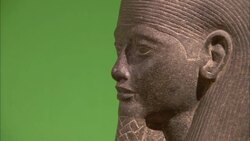 An Egyptian statue stands against a green wall. Stock Footage