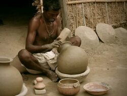 Experienced Indian potter making a pot by beating it gently Stock Footage