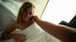 Young woman takes selfie portrait in bed Stock Footage