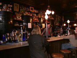 Bartender and customers at bar in pub, Northern Ireland Stock Footage