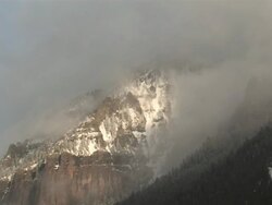 WS View of Clouds and Snow Rolling over Majestic Mountain Peaks in evening Light / Telluride, Colorado, United States Stock Footage