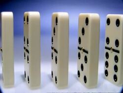 High Speed Dominoes - CU row of side angled dominoes evenly spaced falls over across frame Stock Footage