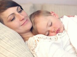 Young mother and her baby, sleeping in bed Stock Footage