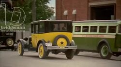Car driving through town, 1930s - reenactment, clip 2 Stock Footage