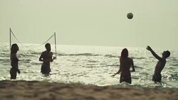 Friends play beach volley in the sea Stock Footage