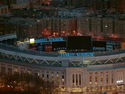 Aerial close up of Yankee Stadium with zoom out to reveal the Bronx at night, NYC Stock Footage