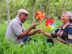 Senior couple playing with pinwheels in the park, Delhi, India Stock Footage