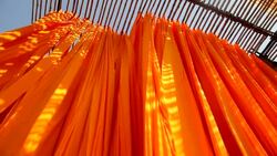 Newly dyed fabric hangs from Bamboo poles to dry at the Sari garment factory in Jaipur, India. Stock Footage