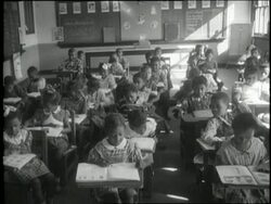 A teacher works with her students in an African American classroom. News Clip