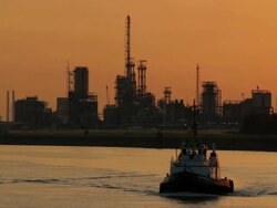 WS View of Belgium, Port of Antwerp, tow boat against skyline of petroleum industry at dusk /Antwerp, Antwerp, Belgium Stock Footage