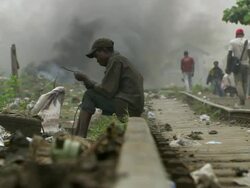 WS View of man sitting on railway line sorting through electric cable and men recovering copper pipe from old heat exchangers / Lagos, Nigeria Stock Footage