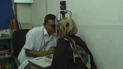 An elderly woman has an eye examination and test by an optician before being given new glasses by a healthcare NGO in rural Bangladesh operating from a hospital ship Stock Footage