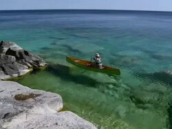 WS PAN Man canoeing at Georgian bay shoreline / Tobermory, Ontario, Canada Stock Footage
