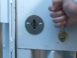 Medium Close Up pan-left pan-right - Hands close the door to a detention cell and turn the lock with a key. / USA Stock Footage