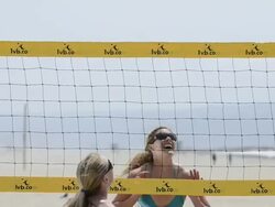 CU of female beach volleyball players spiking and blocking at the net. Stock Footage