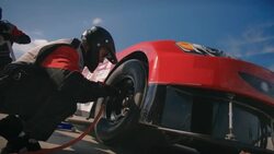 Pit-crewman tightens new race-car tire lug-nuts Stock Footage