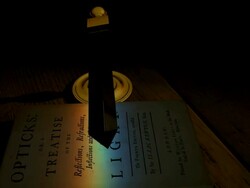 Frontispiece of Isaac Newton's 'Opticks', with a spectrum of light cast upon it by a rotating prism above. Stock Footage