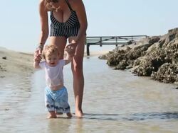 MS Shot of mother and baby walking on beach / St Simon's Island, Georgia, United States Stock Footage