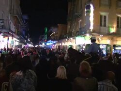 Medium Shot - People milling about on Bourbon Street at night; policeman on horse makes his way through the crowd / New Orleans Louisiana Stock Footage