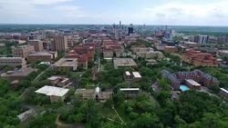 UT Tower Aerial Fly by Austin Texas Over University of Texas at Austin Capital Cities with Downtown Cityscape Skyline in the background at Center moving forwards close with Pool and Amazing Architecture and Church in View Stock Footage