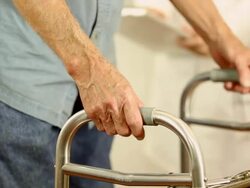 Female doctor helps senior man patient use walker. Holding hands. Stock Footage