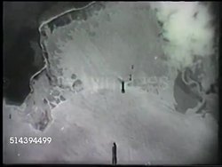 1942: BOMBING OF DARWIN:  VS Imperial Japanese Army Mitsubishi G4M Type 1 'Betty' ('Flying Cigar') flying, dropping bombs over port city Darwin in Australia, explosion &amp; smoke across landscape. WWII, World War II, Pacific Front, bombing run, air rai Instructional Video
