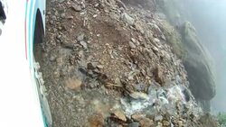 A tire rolls over a narrow road near the edge of a cliff. Stock Footage