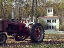 New England farmhouse with rusted tractor fall Stock Footage