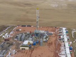 MS AERIAL DS Shot of oil drilling rig at Bakken oil field in snowy fields near Watford City / Watford City, North Dakota, United States Stock Footage