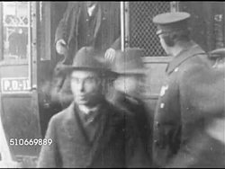 1920: THE RED SCARE: WS Men in coats & hats walking on city sidewalk, MS Men in coats & hats getting out of police wagon ('paddy wagon'), PAN INT Courtroom w/ jury taking seats. DEPORTATION: Women & men being escorted out of building. Anti-communism. Instructional Video